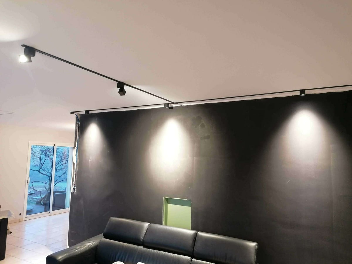 Rail de spots orientables éclairant un mur intérieur