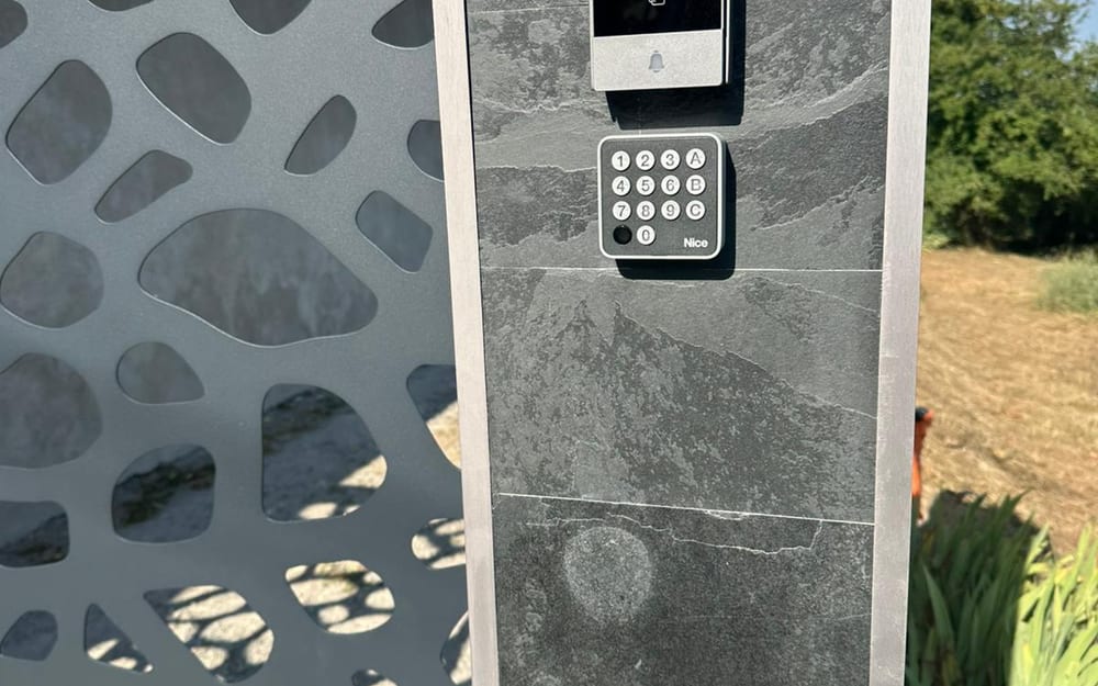 Visiophone et clavier codé installés sur un pilier d'entrée